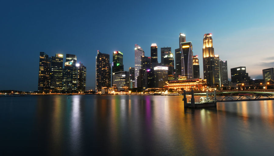 Illuminated buildings in city against sky at night
