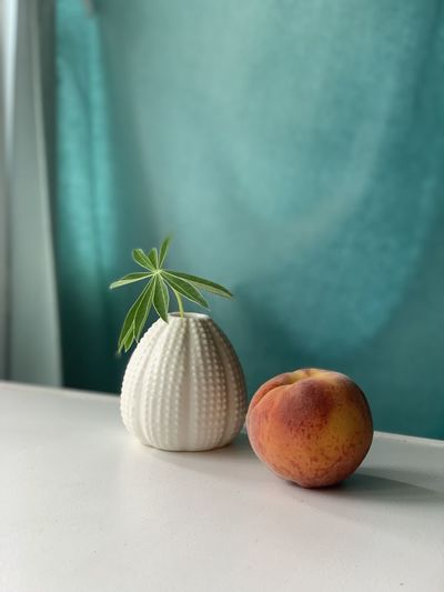 Close-up of fruits on table against wall