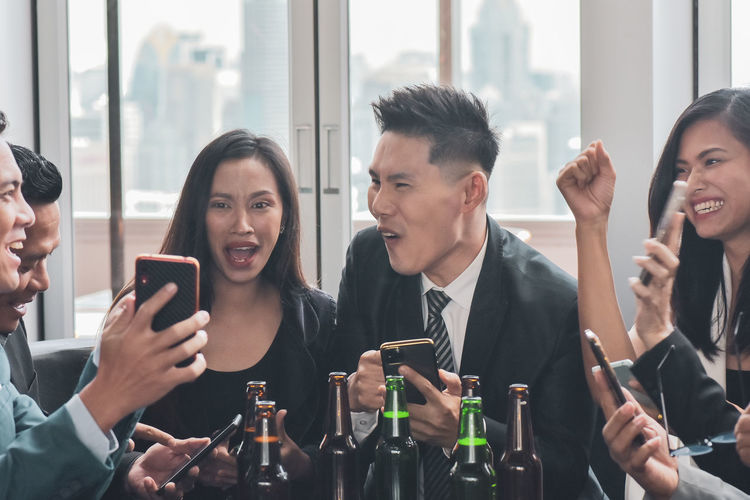 Colleagues using smart phone at restaurant