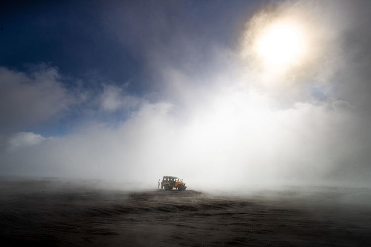 A lonely car on the sand dune surrounded by the fog