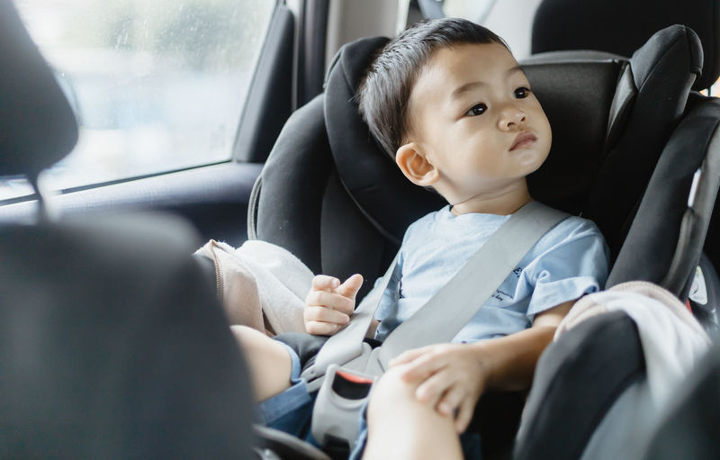 Close-up of cute baby boy sitting in car