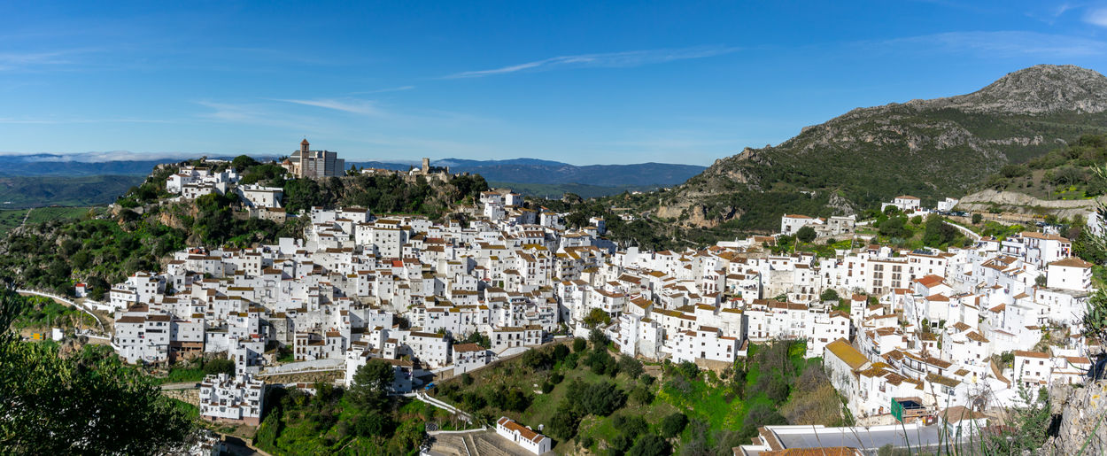 Panoramic shot of townscape and mountains against sky