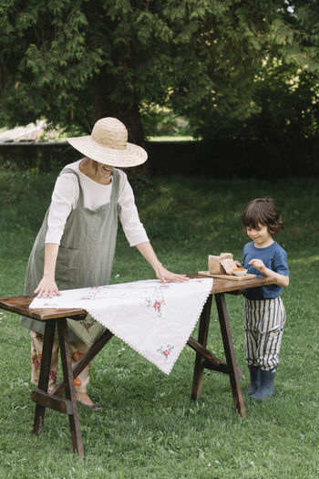 Female hand cutting bread on cutting board in garden