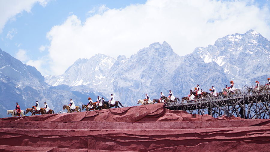 Group of people against snowcapped mountain 