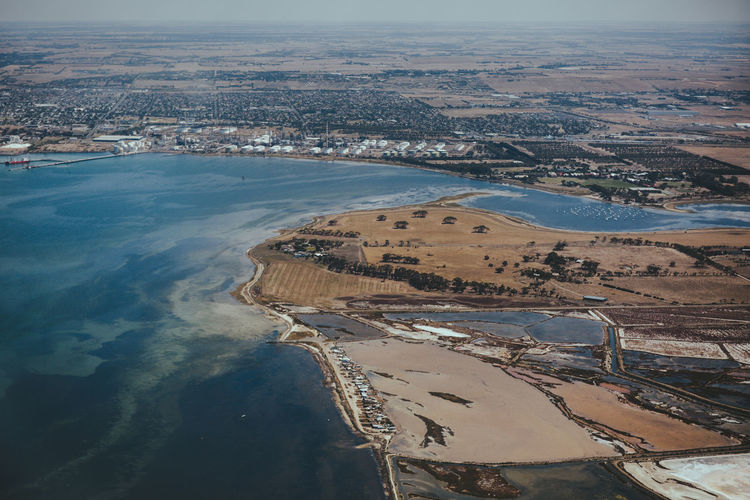 High angle view of city by sea against sky