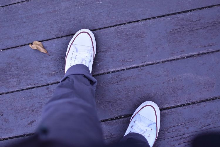 Low section of man standing on footpath