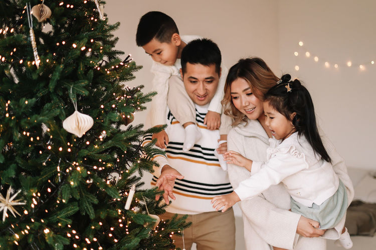 An asian multi-racial family with two children celebrate the christmas holiday in a decorated house