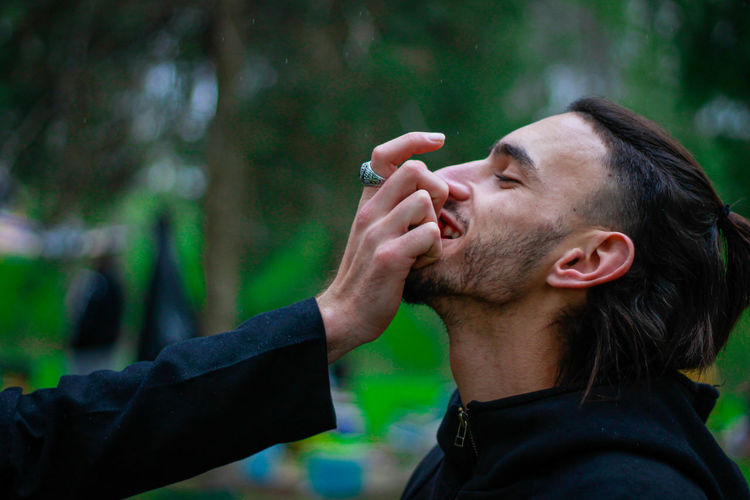 Side view portrait of man smoking cigarette outdoors