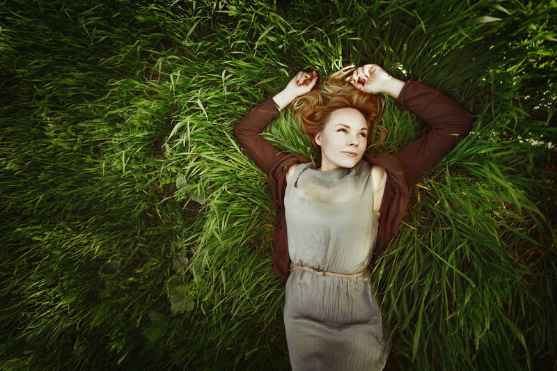 High angle view of smiling woman lying on grass