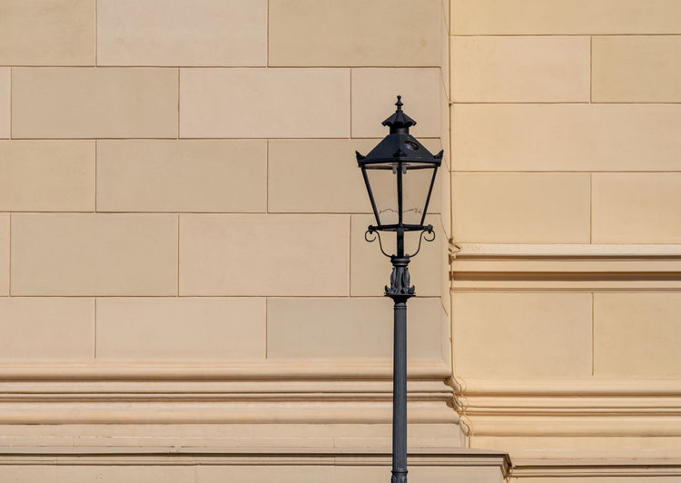 Low angle view of street light against wall
