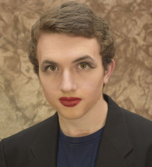 Close-up portrait of young man with red lipstick