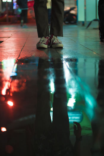 Low section of person standing on wet floor