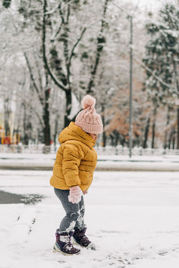 Full length of girl standing on snow covered land outdoors