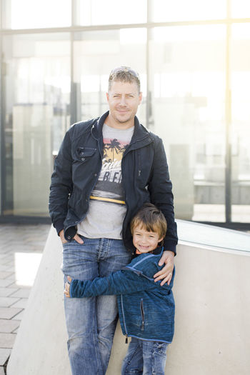 Portrait of father standing with son outside building