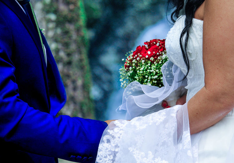 Close-up of couple holding bouquet