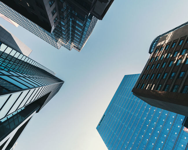Low angle view of modern buildings against clear blue sky