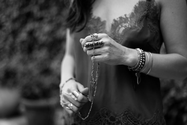 Midsection of woman holding chain while standing outdoors