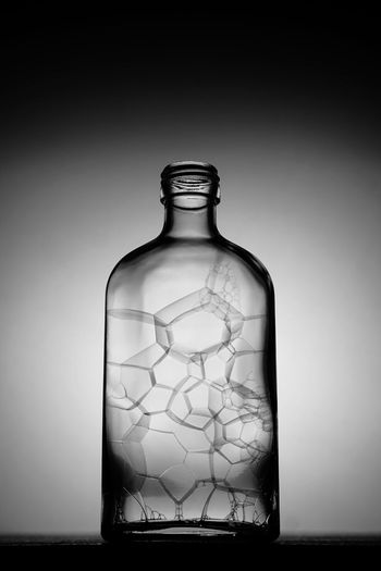 Digital composite image of glass bottle against sky