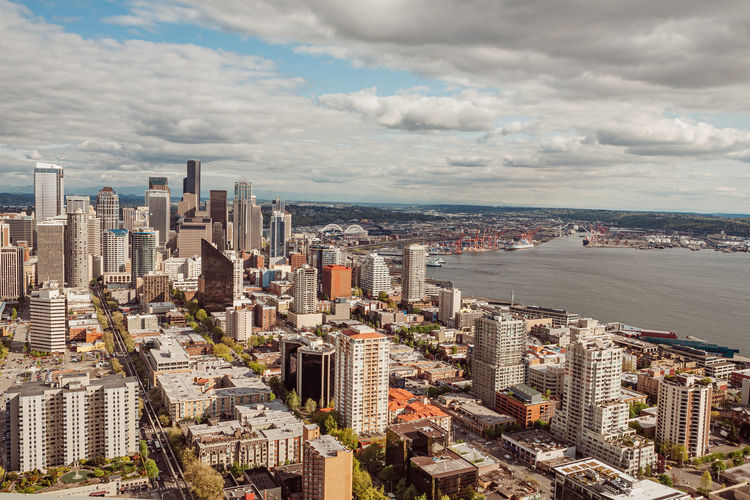 High angle view of city buildings against cloudy sky