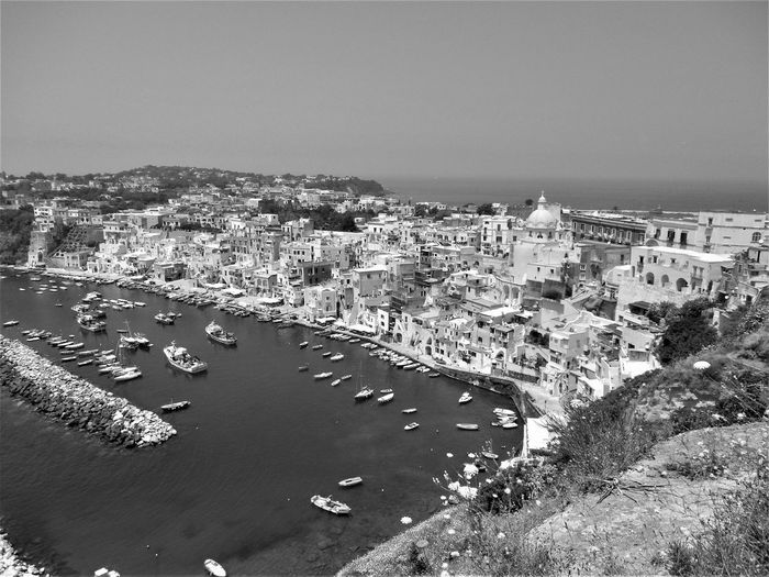 High angle view of townscape by sea against clear sky