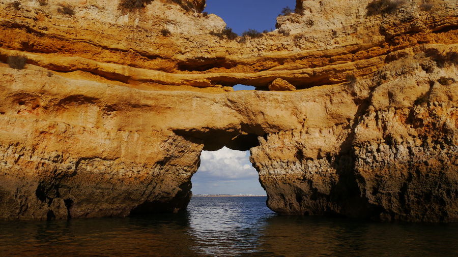 Boattrip through natural arches at ponte de piedade, portugal