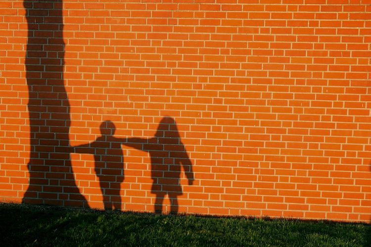 Shadow of children on brick wall