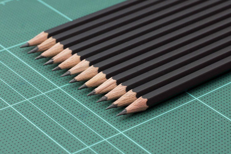 Close-up of pencils on paper cutting mat