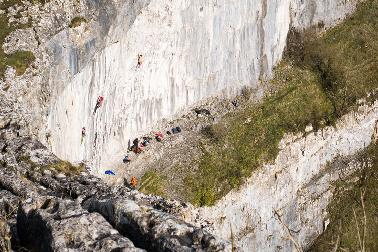High angle view of people on cliff by mountain