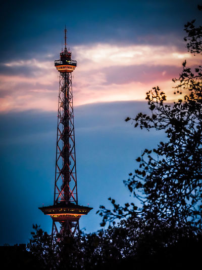 Low angle view of illuminated tower against sky at sunset
