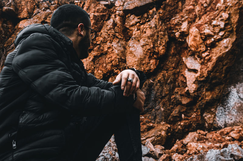Side view of young man holding rock