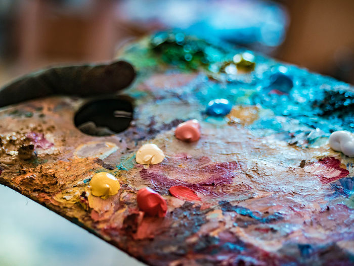 Cropped hand of painter holding colorful paints in palette