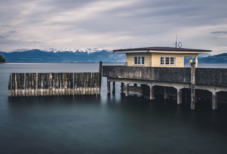 View of building by sea against cloudy sky