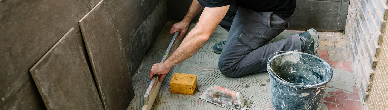 Low section of man working on cement