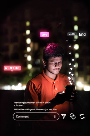 Young man using mobile phone at night
