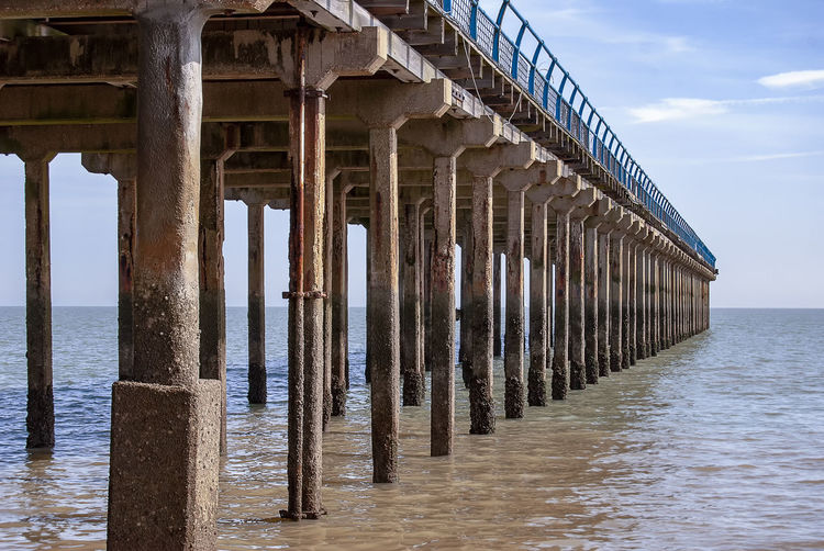 Wooden pier on sea against sky
