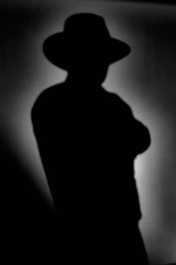 Rear view of silhouette man standing against black background