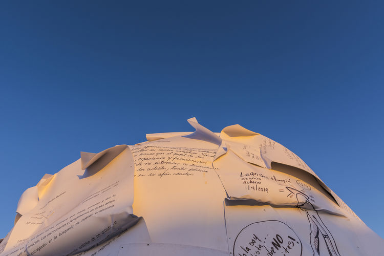 Low angle view of text against clear blue sky
