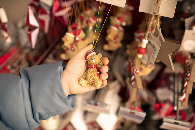 A child holds a toy bear for a christmas tree in a store