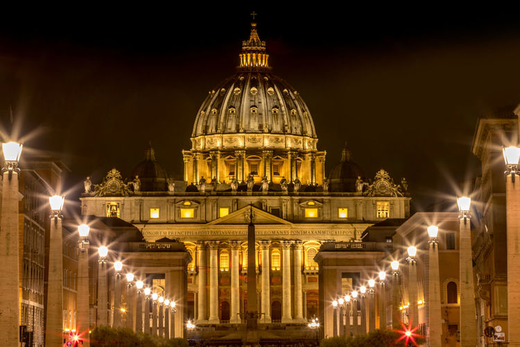 Illuminated st peters basilica against sky in city at night
