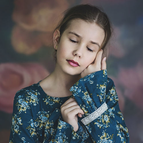 Close-up of girl with eyes closed and hands on cheek
