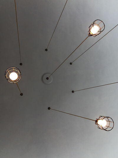 Directly below shot of illuminated light bulbs hanging from ceiling
