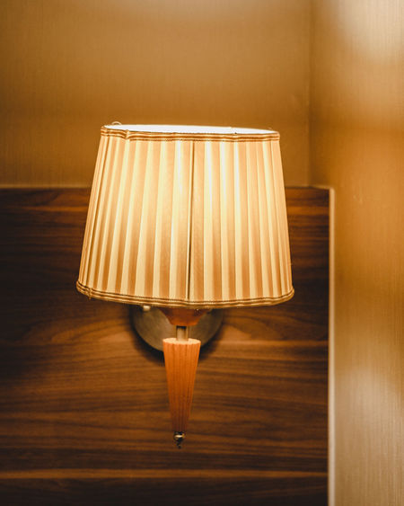Close-up of illuminated lamp against wall