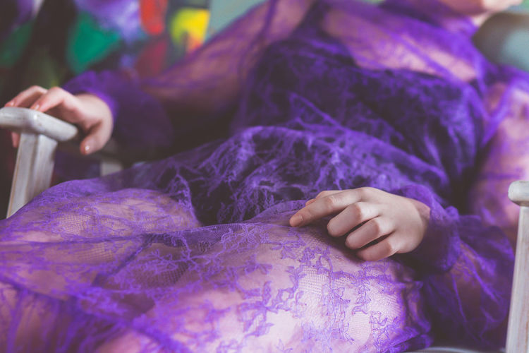 Midsection of a woman with purple dress