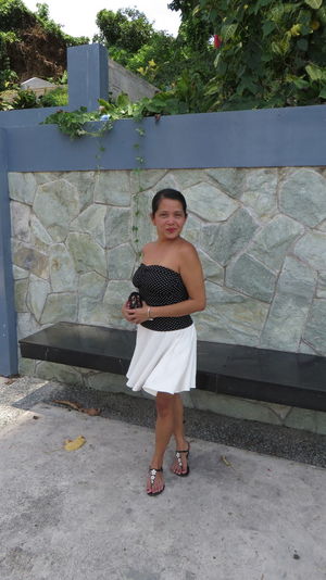 Full length portrait of woman standing against wall