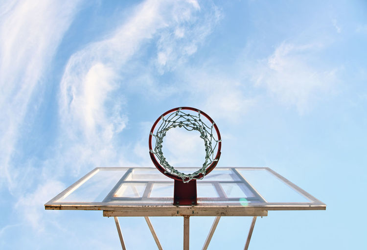 Close up empty basketball basket hoop at outdoors court over background of blue sky