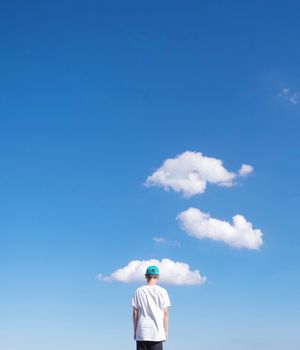 Low angle view of boy against blue sky