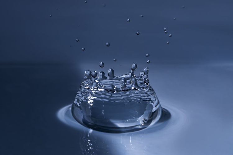 Close-up of splashing water drop hitting water surface
