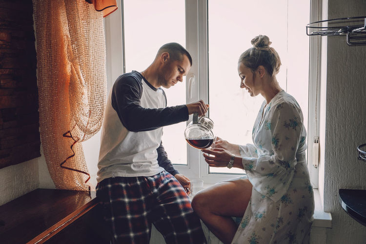 Young couple drinking coffee in kitchen at home in the morning. young happy couple, newlyweds