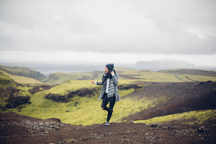 Woman standing on landscape against mountain range
