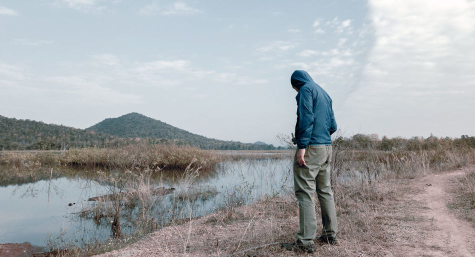 Full length of man standing by lake against sky